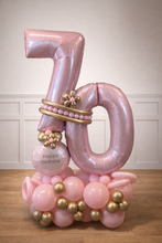 Load image into Gallery viewer, Pink and gold number 70 balloon decoration on a wooden floor with a white wall background.