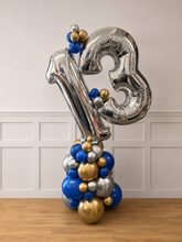 Load image into Gallery viewer, Silver number 13 balloon with blue and gold balloons against a white wall.