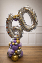 Load image into Gallery viewer, Balloon arrangement with number '60' on a wooden floor against a white paneled wall.