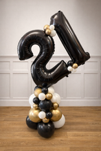Load image into Gallery viewer, Black, gold, and white balloon arrangement with number '21' on a wooden floor.