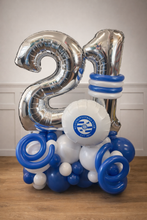 Load image into Gallery viewer, Silver '21' balloons with blue and white accents on a wooden floor.