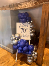 Load image into Gallery viewer, Decorative balloon arch with a sign indicating a 70th birthday celebration, placed against a wooden wall.