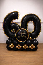 Load image into Gallery viewer, Black and gold balloon arrangement shaped like the number 60 with 'Happy Birthday' text on a wooden surface.
