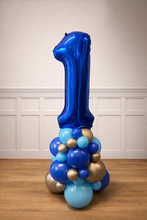 Load image into Gallery viewer, Blue balloon number '1' with smaller balloons on a wooden floor against a white paneled wall.
