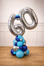 Load image into Gallery viewer, Balloon sculpture with number '60' in silver, blue, and silver balloons on a wooden floor.
