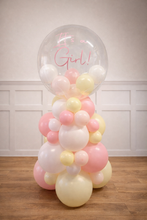 Load image into Gallery viewer, Balloon sculpture with pastel colors and 'It's a Girl!' text on a wooden floor.
