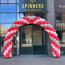 Load image into Gallery viewer, A spiral balloon arch with red and gray balloons, set up in front of a business entrance.
