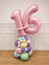 Load image into Gallery viewer, Pastel-colored balloon sculpture with number '16' against a white paneled wall.
