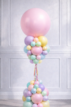Load image into Gallery viewer, Pastel-colored balloons arranged in a decorative display against a white paneled wall.
