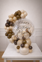 Load image into Gallery viewer, Balloon arrangement with a transparent balloon displaying 'Happy Birthday Myrah' on a white table.
