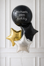 Load image into Gallery viewer, Black balloon with 'Michaels 28th Birthday' text, gold star balloon, and silver star balloon against a white paneled background.
