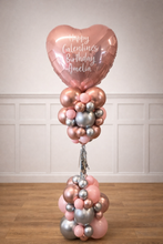 Load image into Gallery viewer, Balloon bouquet with a heart-shaped balloon reading 'Happy Valentine's Birthday Amelia' against a white paneled wall.
