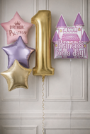 Decorative balloons including a gold number '1', star-shaped balloons, and a castle-shaped balloon against a neutral background.