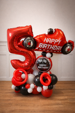 Load image into Gallery viewer, Balloon arrangement with number 5 and race car design on a wooden floor.
